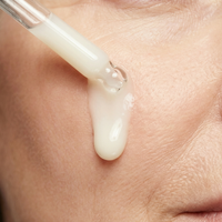 Skincare product being applied to skin with a dropper.